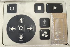 Bedienpanel am Q500 Lasercutter bestehend aus: Knöpfe obere Reihe von Links nach Rechts Power, Stop und Start. Links unterhalb befindet sich ein Steuerkreuz mit Home Taste in der Mitte. Rechts davon ist Shift Knopf und darunter ein Knopf zur Steuerung der Absaugung.